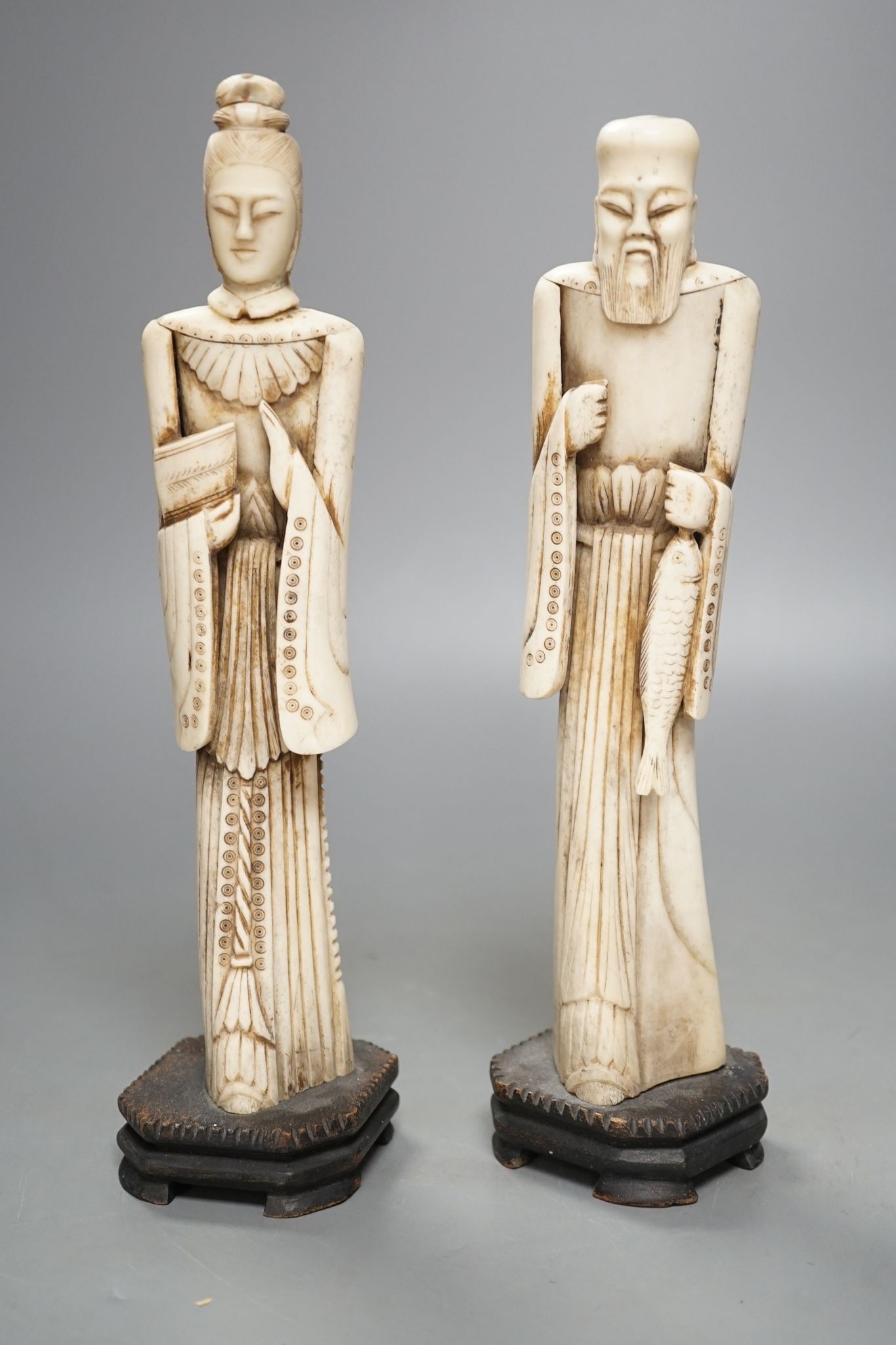 A pair of Chinese carved bone figures, Tallest 27 cms high.
